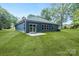 Rear exterior of the house with a sliding glass door, windows, and a well-maintained lawn at 337 Autumn Dr, Harrisburg, NC 28075