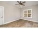 Bedroom featuring hardwood flooring, a ceiling fan, and natural light from a large window at 1025 Readsboro Dr # 11, Mt Ulla, NC 28125
