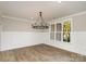 Elegant dining room with wainscoting, hardwood floors, a modern chandelier, and a large window at 1025 Readsboro Dr # 11, Mt Ulla, NC 28125