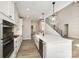 Open-concept kitchen with white cabinets, stainless appliances, island, and view of the staircase at 1025 Readsboro Dr # 11, Mt Ulla, NC 28125