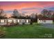 Exterior of home at sunset with white shed, country details and green front lawn at 1812 Shearers Rd, Davidson, NC 28036