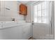 White washer and dryer, plus extra storage in this laundry room with exterior access at 1812 Shearers Rd, Davidson, NC 28036