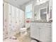 Cozy bathroom with a butterfly-themed shower curtain, white vanity, and neutral tile flooring at 2657 Cheverny Pl, Concord, NC 28027