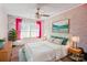 Bedroom with a ceiling fan, large painting, modern light fixtures, and bright pink curtains at 2657 Cheverny Pl, Concord, NC 28027