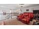 A bonus room area featuring red leather recliners, neutral carpet and open access to the staircase at 2657 Cheverny Pl, Concord, NC 28027