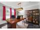 Stylish home office with a unique wooden desk, bookshelf, and natural light at 2657 Cheverny Pl, Concord, NC 28027