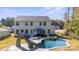 A sparkling backyard pool and slide adjacent to a patio, hot tub, and the home's rear elevation at 2657 Cheverny Pl, Concord, NC 28027