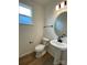 A clean half bathroom showcases a pedestal sink, oval mirror and wood-look tile flooring at 3014 Cunningham Farm Dr, Indian Trail, NC 28079