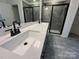 Bathroom featuring double sinks with quartz countertop, modern fixtures, and stylish glass-enclosed shower at 3014 Cunningham Farm Dr, Indian Trail, NC 28079