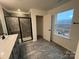 Contemporary bathroom featuring a double vanity, glass-enclosed shower, and large window overlooking the yard at 3014 Cunningham Farm Dr, Indian Trail, NC 28079