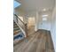 Inviting foyer with wood-look flooring and a staircase with modern black iron spindles at 3014 Cunningham Farm Dr, Indian Trail, NC 28079