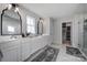 Modern bathroom with double sinks, elegant mirrors, and a walk-in closet at 7248 Waterwheel Sw St, Concord, NC 28025