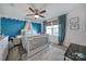 Charming bedroom featuring an accent wall, ceiling fan, and window with natural light at 7248 Waterwheel Sw St, Concord, NC 28025