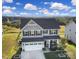 Beautiful two-story home with a three-car garage and well-manicured front yard at 7248 Waterwheel Sw St, Concord, NC 28025