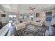 Bright, open-concept living room featuring a large sectional, stylish rug, and plenty of natural light at 7248 Waterwheel Sw St, Concord, NC 28025