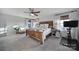 Spacious main bedroom with a wooden bed frame, neutral decor, and light-filled windows at 7248 Waterwheel Sw St, Concord, NC 28025