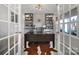 Elegant office with built-in shelving, a large desk, and ample natural light through french doors at 7248 Waterwheel Sw St, Concord, NC 28025