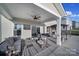 Relaxing covered patio with ceiling fan, outdoor furniture, and a view of the backyard at 7248 Waterwheel Sw St, Concord, NC 28025
