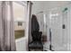 Bright bathroom with a glass-enclosed shower, decorative chair, and window with natural light at 1109 Freeman View Dr, Albemarle, NC 28001