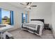 Comfortable bedroom with a queen-size bed, ceiling fan, and bright windows with blue curtains at 1109 Freeman View Dr, Albemarle, NC 28001