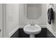 Elegant powder room with a pedestal sink, decorative mirror, and neutral wall colors at 1109 Freeman View Dr, Albemarle, NC 28001