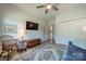 Inviting bedroom includes a blue sofa bed, ceiling fan, TV, and a wooden accent chair, providing a cozy space at 2014 Newstyle Way, Tega Cay, SC 29708