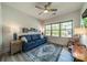 Comfortable bedroom featuring a blue sofa bed, area rug, and natural light from the large window at 2014 Newstyle Way, Tega Cay, SC 29708