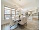 Bright dining area features a modern chandelier, stone table, white seating and an open floorplan that leads to the kitchen at 2014 Newstyle Way, Tega Cay, SC 29708