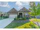 Beautiful brick home features a well-maintained lawn, professional landscaping, and an attached two-car garage at 2014 Newstyle Way, Tega Cay, SC 29708