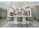 Bright kitchen with white cabinets, range hood, tile backsplash, modern island with bar stools and pendant lighting at 2014 Newstyle Way, Tega Cay, SC 29708