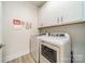Bright laundry room with white cabinetry and modern washer and dryer appliances at 2014 Newstyle Way, Tega Cay, SC 29708