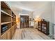 Home library with built-in wooden bookshelves, a display cabinet, decorative furnishings, and light hardwood floors at 2014 Newstyle Way, Tega Cay, SC 29708