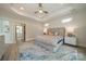 Well-lit main bedroom featuring a tray ceiling, ceiling fan, and large bed; the entrance to the ensuite is visible at 2014 Newstyle Way, Tega Cay, SC 29708
