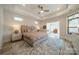 Spacious main bedroom with a tray ceiling, ceiling fan, neutral decor, and an adjacent sitting area at 2014 Newstyle Way, Tega Cay, SC 29708