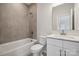 Modern bathroom with a white vanity, bathtub, and grey tile at 123 Kepli Way, Mooresville, NC 28115