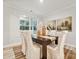 Dining room with a dark wood table, light beige chairs, and a large window at 123 Kepli Way, Mooresville, NC 28115