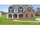 Inviting two-story home features a brick facade, covered porch, and manicured lawn at 123 Kepli Way, Mooresville, NC 28115