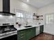 Modern kitchen with dark green cabinets and stainless steel appliances at 301 S Washington St, Monroe, NC 28112