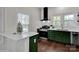 Modern kitchen with dark green cabinets, quartz countertops, and stainless steel appliances at 301 S Washington St, Monroe, NC 28112