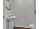 Small powder room with pedestal sink and dark wood floor at 301 S Washington St, Monroe, NC 28112