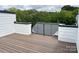 This home features a spacious wood deck with white trim and wrought iron railing overlooking mature trees at 2035 Belmont Terraces Ln # 5, Charlotte, NC 28205