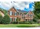 Brick two-story house with lush landscaping and black shutters at 4813 Cambridge Crescent Dr, Charlotte, NC 28226