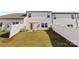 A view of the backyard with a white fence, patio, and a manicured lawn with an umbrella-covered table at 7059 Duncan Acres Dr, Belmont, NC 28012