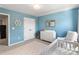 Bedroom with blue walls, white furniture including crib and changing table, and charming nautical decor at 7059 Duncan Acres Dr, Belmont, NC 28012