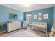 Bright Bedroom features blue walls, a crib, changing table, a comfortable chair, and stylish décor at 7059 Duncan Acres Dr, Belmont, NC 28012