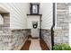 Charming front entrance with a white door, decorative wreath, and stylish stone accents at 7059 Duncan Acres Dr, Belmont, NC 28012