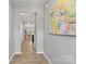 Bright hallway leads to the living area, adorned with a colorful painting and modern flooring at 7059 Duncan Acres Dr, Belmont, NC 28012