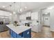 Stylish kitchen island with white countertop and modern pendant lighting, flowing into the entryway at 7059 Duncan Acres Dr, Belmont, NC 28012