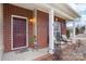 Brick front porch with two wicker chairs and a colorful rooster statue at 7206 Sandown Ct, Harrisburg, NC 28075