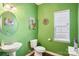 Bright powder room with green walls, pedestal sink, and decorative accents at 7206 Sandown Ct, Harrisburg, NC 28075